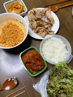 several bowls of food on a table with chopsticks