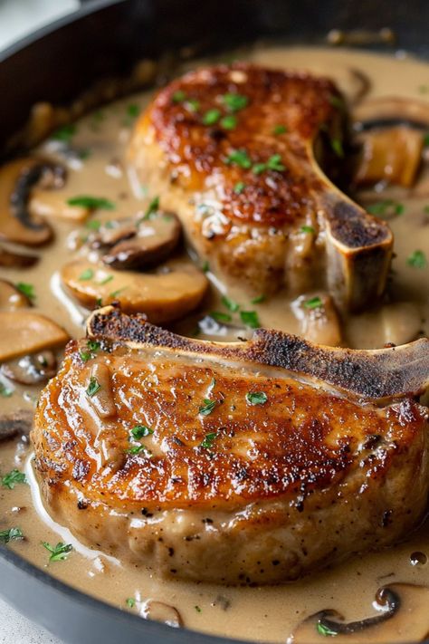 These smothered pork chops with mushroom gravy are such a hearty treat! This one-pan meal is sure to please the entire family. Mushrooms And Pork Chops, Pork Steaks And Gravy, Pork With Mushroom Sauce, Mushroom Pork Chops Oven, Smoothed Pork Chops, Pork Chops With Brown Gravy, Smother Pork Chops, Pork Chops With Mushroom Soup, Pork Chop Meals