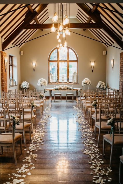 Beautiful aisle decor - white rose petals line the aisle with rose and gypsophilia bunches tied to the chairs - large displays either side of ceremony table with a long low display - nuthurst grange wedding venue - penny johnson flowers coleshill Wedding Aisle Decorations Rose Petals, White Roses Aisle Decor, Rose Petals Aisle Wedding, Petal Isle Wedding, Wedding Aisle Flower Petals, Indoor Wedding Aisle Decor, Rose Petal Wedding Aisle, White Rose Petals Down Aisle, Rose Petals Down Aisle