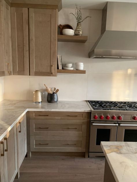 Floating Shelves By Stove, Natural Wood Kitchen Cabinets Gray Floor, Alaska Kitchen Design, Natural Wood Kitchen Cabinets With Stainless Steel Appliances, Organic Modern Kitchen Shelves, Nutmeg Cabinets Kitchens, Organic Looking Kitchen, Organic Modern Countertops, Cool Tone Wood Kitchen Cabinets