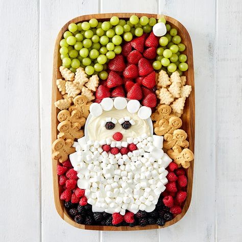 A wood food board decorated with fruit and cookies and marshmallows to look like Santa. Holiday Fruit Platter, Santa Charcuterie Board, Festive Fruit Platter, Santa Charcuterie, Sweets Board, Holiday Boards, Charcuterie Board Meats, Santa Snacks, Holiday Fruit