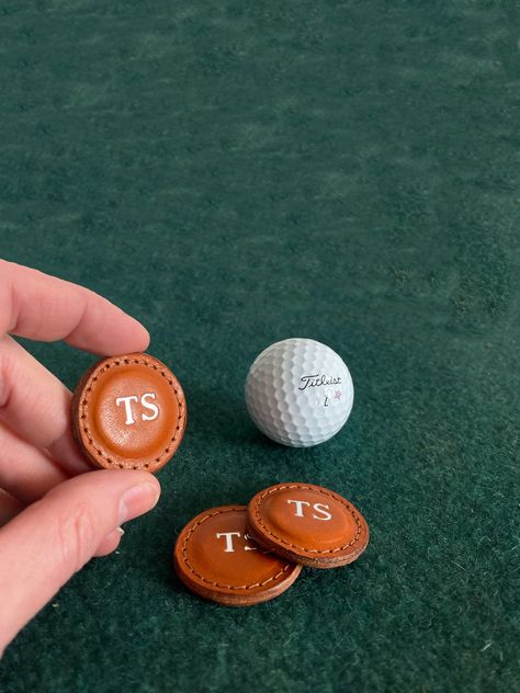 Give your favorite golfer a gift they’ll cherish with these classic leather Golf Ball Markers, handmade in the USA from high-quality full-grain vegetable-tanned leather. This set of two beautifully crafted markers features fine stitching and edge finishing, offering a luxurious touch to the golf course. Each marker can be personalized with a 2-letter monogram, making it a thoughtful and unique gift for any golf lover. These durable and stylish markers are perfect for use on the green, and their Golf Leather Goods, Golf Ideas For Him, Leather Golf Accessories, Random Golf Club, Personalized Diy Gifts, Golf Gifts For Women Ideas, Diy Golf Gifts, Favorite Things Gift Ideas, Golf Giveaways