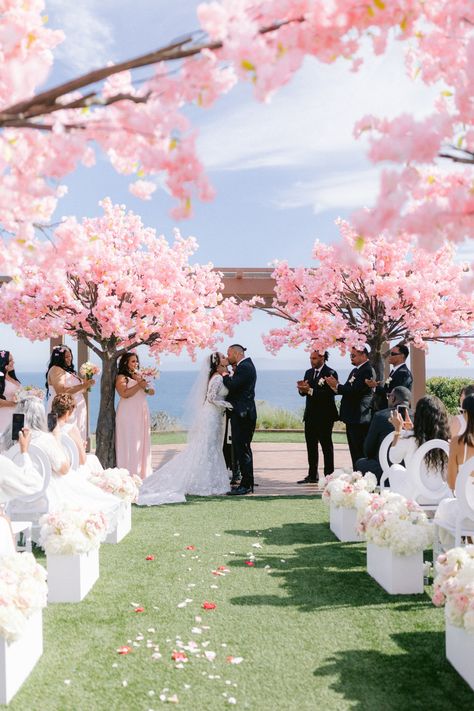 An aisle lined with pink cherry blossom trees is a show-stopping guest favorite. See more photos of this elegant outdoor wedding here, including a sushi and frosé bar. Pink And White Wedding Aesthetic, Wedding Japanese Theme, Cherry Blossom Chuppah, Weddings In Japan, Wedding In Japan, Wedding Cherry Blossom Theme, Japanese Cherry Blossom Wedding Theme, Wedding Flowers Cherry Blossom, Cherry Blossom Wedding Theme Decoration