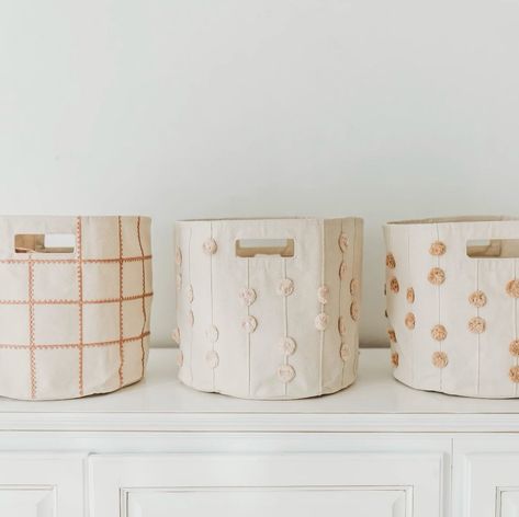 Our infamous storage bins are the perfect way to keep toys and books organized in any part of your home! They are made to be durable for holding all of your little one’s prized possessions with collapsible fabric and handles for easy movement. They currently come in 2 different styles: Lace and PomPom, both featuring a variety of color options! 🧸 Are you team Lace or PomPom? #kidsstoragebasket #storagebasket #toddlerstoragebasket #babybasket #babybrand #toddlerclothes #organiccottonclothi... Baby Nursery Laundry Basket, Baskets For Nursery, Nursery Organization Baskets, Toy Storage Bin, Kids Storage Baskets, Linen Closet Storage, Soft Toy Storage, Portable Changing Pad, Mini Crib Sheets