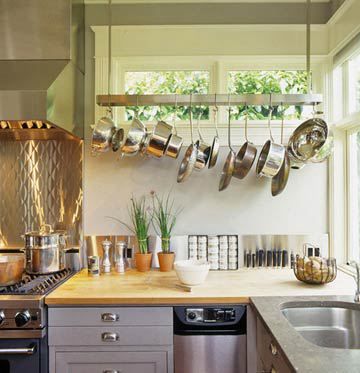 Free up some good cabinet space and get your pots dangling from the ceiling. You don’t need a huge kitchen to do this. I love how this tight kitchen simply places the pots just along the wall. It brightens up the space too as the light from the window reflects off the silver pots. Your eyes are directed upward too–which makes the entire space feel bigger even if you have a low ceiling. Pot Rack Kitchen, Pan Storage, Pot Rack Hanging, Kitchen Pot, Kitchen Upgrades, Tiny Apartment, Pot Rack, Hanging Pots, Stylish Kitchen