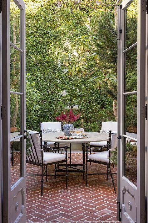 A stone top dining table sits on red brick herringbone pavers and is surround by wrought iron patio dining chairs. Red Brick Pavers Backyard, Red Brick Herringbone Patio, Herringbone Brick Patio, Herringbone Pavers, Red Brick Patio, Red Brick Pavers, Brick Herringbone, Herringbone Brick, Vege Garden