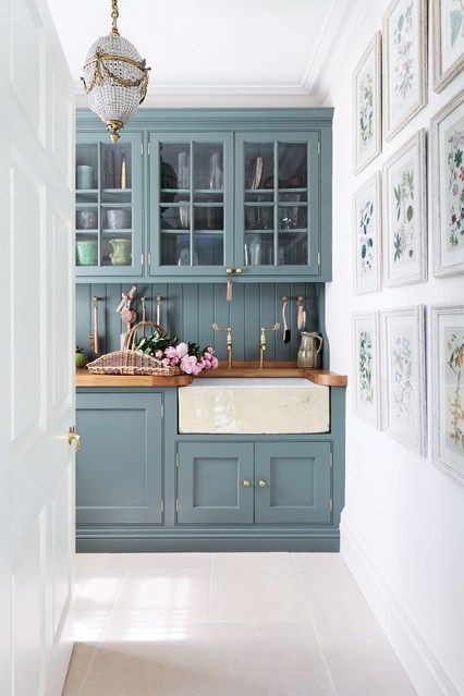 'Anyone can pick a paint colour, but getting the structure right is what makes a house', says Amanda Hornby, the interior designer who tranformed this Cotswolds dovecote into a family home. Amanda designed the cupboards in the kitchen, painted in Farrow & Ball's 'Card Room Green'. The green tone of the cupboards adds a fresh feel to the room, complimented by the green tones in the artwork on the gallery wall. Brass taps and fixtures give a feel of elegance to the simple style of the space. Railings Kitchen, Kitchen Paint Schemes, Casa Disney, Kitchen Cabinet Inspiration, Sophisticated Bathroom, Kabinet Dapur, Blue Kitchen Cabinets, Cabinets Ideas, Green Kitchen Cabinets