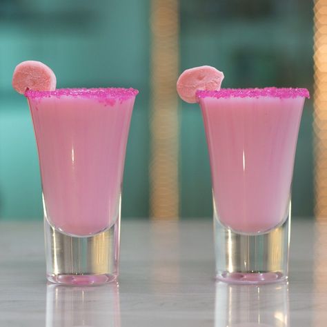 Blow your mind and some bubbles with this Coconut Bubble Gum Shot. This bright pink drink is made of bubble gum-infused rum, piña colada drink, and cream of coconut, and is garnished with pink sugar and a piece of bubble gum. Seriously though, this drink has Bazooka flavor. Pink Barbie Cocktails, Pink Shot Recipes, Pink Shots Alcohol, Pink Shooters, Starburst Shots, Pink Pina Colada, Pink Shots, Infused Rum, Candy Shots