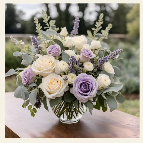 Deepest Sympathies Floral Arrangement Description: Express your heartfelt condolences with our exquisite "Deepest Sympathies Floral Arrangement." This thoughtfully curated bouquet combines the timeless elegance of lavender and white roses, creating a serene and comforting display that conveys your deepest sympathies. Standard: A fuller bouquet for those who want a bit more floral beauty: 12" L x 12" W x 16" H Traditional Elegance: A statement piece that’s sure to impress: 14" L x 14" W x 20" H E Purple And White Flower Arrangements Centerpieces, Sterling Roses Bouquet, Lavender Hydrangea Centerpiece, Simple Purple Flower Arrangements, Lavender Wedding Arrangements, Lavender And White Centerpieces, Fresh Floral Centerpieces, Lavender And White Flower Arrangements, Wedding Flowers Purple Lavender