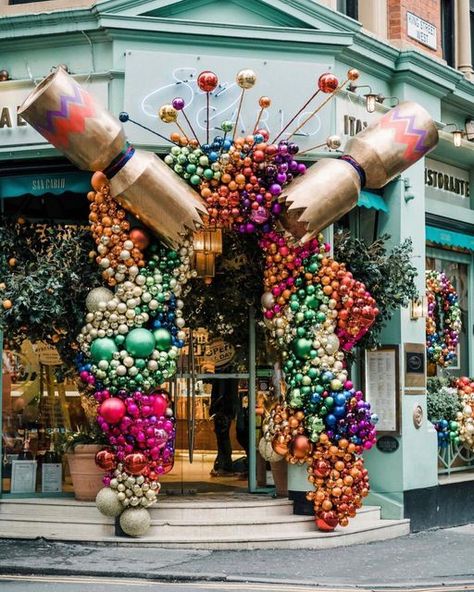 Early Hours London Ltd on Instagram: "| SAN CARLO MANCHESTER • Christmas decoration for @sancarlorestaurants • An @earlyhoursltd design & installation • Spreading festive cheer on the streets of Manchester with this enormous cracker showering a rainbow of thousands of baubles over the entrance at @sancarlorestaurants 🎄 Photo @ayeshaphoto #earlyhoursltd #christmasdecor #manchesterstreets #christmasdecorations #eventflorist #eventdecorator #visitmanchester #instachristmas #luxuryflorist #seas Christmas Decor Ideas Boutique, Christmas Installation Display, Large Christmas Installation, Bookstore Christmas Decorations, Diy Christmas Market Stall, Christmas Display Outdoor, Retail Christmas Decor, Ornament Installation, Christmas Shop Decor