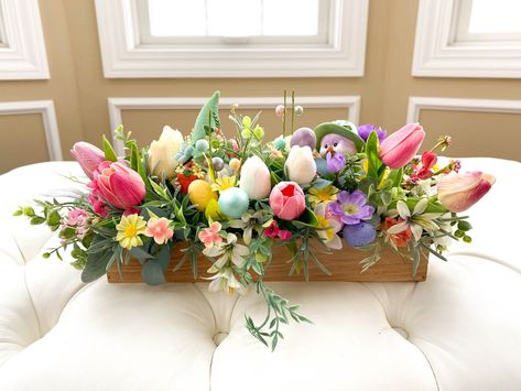 "This Adorable Easter Spring Flower Centerpiece will bring the spring season right into your home. Only one available. Arranged in a rectangle wood box, this design contains Easter gnome and chick with eggs tucked away in bursts of beautiful  spring flowers and greenery. Whether you place it on the dinning table, side table, or foyer, it will surly bring the joy of the season.   The wood box is 13.75\"(L) x 4\"(W) x 2\"(H), and the finished design is about 19\"(L) x 10\"(W) x  8\"(H) All designs Easter Floral Arrangements, Flower Box Centerpiece, Beautiful Spring Flowers, Easter Floral Arrangement, Tissue Paper Flowers Diy, Fake Flower Arrangements, Easter Flower Arrangements, Easter Arrangement, Tulips Arrangement