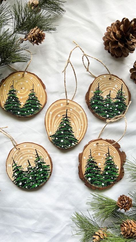 They’re here! — our NEW version of our popular ornaments! These are luxury, hand-painted, wood slice ornaments made to last for years to come. Use our handmade ornaments as a perfect addition to a classic family tradition of decorating the Christmas tree, or use them as gifts to give away for the holidays! — each set of our luxury, hand-painted ornaments contains 5 variously sized wood slices with various pine trees and snow dots (all ornaments are sealed with a protective coating to protect th Wood Puck Ornament, Sliced Wood Christmas Ornaments, Painting Wooden Ornaments Christmas, Small Wood Ornaments, Wood Slices Decor, Woodslice Decoration Christmas, Painted Wooden Disc Ornaments, Christmas Coasters Wood, Christmas Tree Decorations Handmade