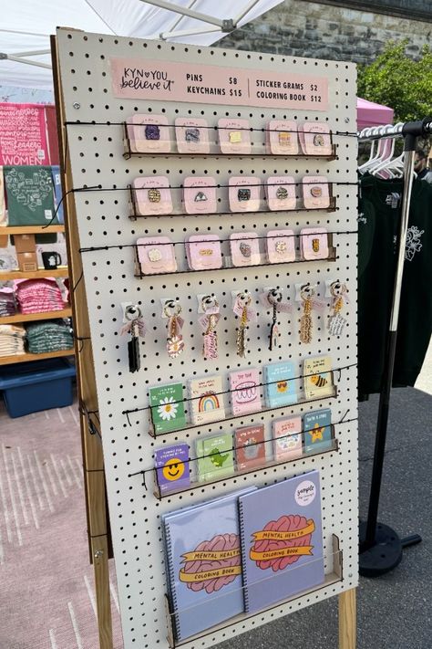 Use a pegboard to display your pins, keychains, and other small items at your market stall. This is a great way to show off your products and make them easy for customers to find. #marketstall #displayideas . #Pin_Display_Ideas_Market #Dollar_Tree_Pegboard_Display #Market_Display_Ideas #Magnet_Display Market Display Ideas, Market Signage, Craft Stall Display, Enamel Pin Design, Pegboard Ideas, Shirt Displays, Art Fair Booth, Vendor Booth Display, Patches Display