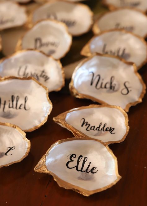 Give the perfect gift with this elegant, chic personalized oyster shell! Shells are finished with a pearlescent sheen and personalizations are hand-painted with tender love & care. Price is per individual shell. Special bulk price available for wedding or event orders. Please contact with inquiries! Shells measure approximately 3-5". All shells are natural, so imperfections may be present. Shells are individually handcrafted, so each is unique and no two are alike! Oyster Opening Pearl Party, Oyster Shell Wedding Favors, Wedding Oyster Shells, Event Moodboard Ideas, Shell Place Cards Wedding, Seashell Wedding Favors, Oyster Shell Seating Chart, Seashells And Wedding Bells Bachelorette, Wedding Inspo Beach