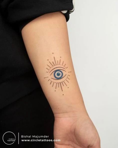 The Evil Eye Tattoo Meaning And 55+ Designs That Offer Protection Evil Eye Tattoo With Color, Evil Eye Neck Tattoos Women, Evil Eye Knee Tattoo, Unique Evil Eye Tattoo, Evil Eye Neck Tattoo, Greek Eye Tattoo, Greek Evil Eye Tattoo, Evil Eye Tattoo Ideas, Tattoo Evil