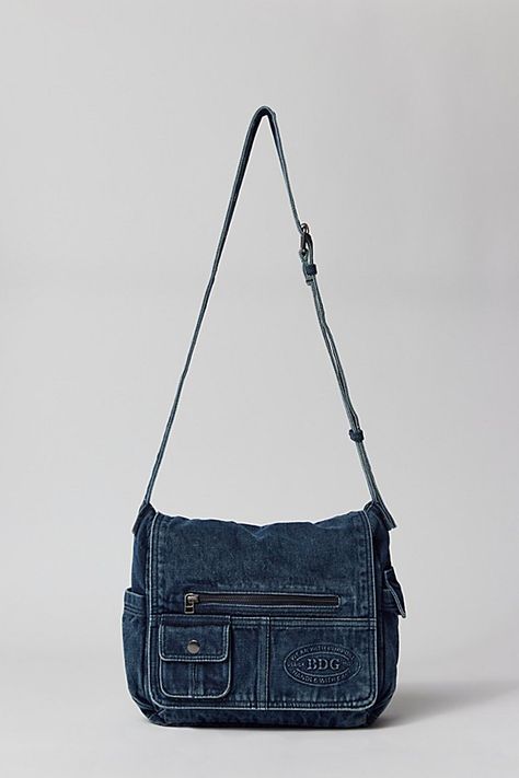 Essential messenger bag crafted from premium BDG denim. Low-profile silhouette with a pocketed flap closure. Lined interior with two pockets and plenty of space for your essentials. Complete with a zip pocket at the back for easy access, plus a water bottle pocket at the side. Finished with an adjustable strap - wear it on your shoulder or crossbody. Urban Outfitters exclusive. Features BDG denim messenger bag Washed soft denim with tons of storage Plenty of pockets inside and out Water bottle p School Satchel Bag, Denim Satchel Bag, Cute Vintage Bags, Cute Everyday Bags, Denim Purses And Bags Old Jeans, Cute Bags And Purses, Cute Bags For School, Streetwear Bags, Indie Bag