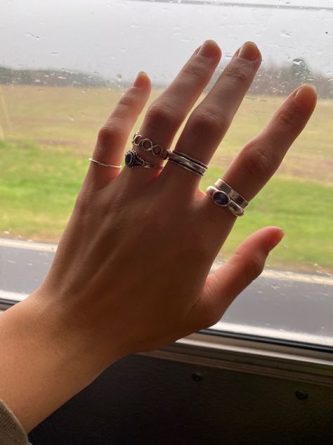 hand with rings painted nails Rings Lesbian Style, Many Rings On Hand Aesthetic, Thumb Rings Aesthetic, Silver Rings Hand, Hands Full Of Rings, Rings Stacking Ideas, Lesbian Rings Hands, Masc Rings For Women, Queer Jewelry Aesthetic