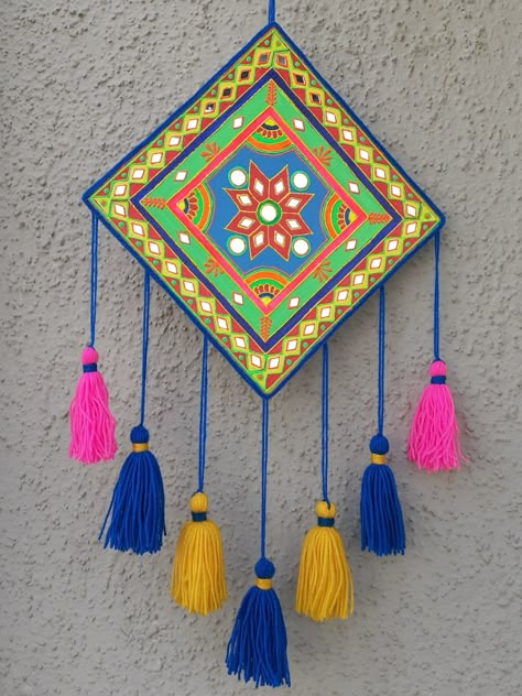 A simple, easy and colorful wall hanging craft idea. I have made it using waste cardboard. Painted it with acrylic colors and decorated with 3D outliners, yarn and some mirrors. This festive season add some colors to your home with this craft idea, its super easy to make. Wall Hanging Painting Ideas Canvas, Cute Wall Hangings Diy, Wall Decoration Craft Ideas, Home Made Wall Hanging, Wall Hanging From Cardboard, Mirror Work On Cardboard, Wall Art With Clay, Craft Hanging Decorations, Mirror Work Wall Hanging