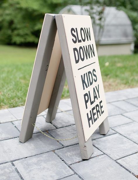 Make this slow kids at play sign DIY wooden frame sign from scrap 2x4 wood. Diy Slow Down Sign, Standing Wood Sign, Diy Folding Sign, Diy Sandwich Board Sign, Sandwich Board Signs Diy, Diy Outdoor Signs Business, A Frame Sign Diy, A Frame Sign Ideas, Diy Sidewalk Sign