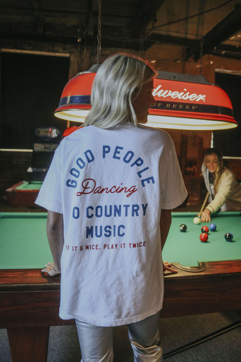 Put Johnny on the vinyl to get all the cowboys and cowgirls on the dance floor. We love when good people are boot scootin' to country music. This white tee features a fun blue and red front and back graphic. Western Graphic Tees Outfit, Red Tee Outfit, Country Dancing Aesthetic, Vinyl Sweatshirt Ideas, Country Winter Outfits, Austin City Limits Outfit, Chic Western Outfits, Country Music Aesthetic, Country Music Outfits