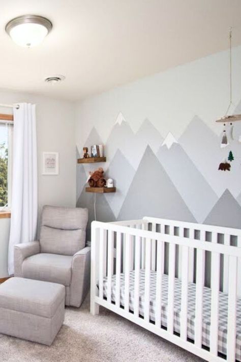 The Baby nursery has a gray mountain mural behind a crib and chair.