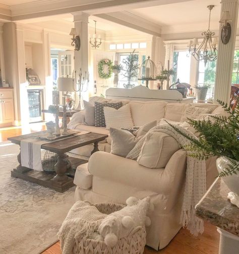 The relaxed, lived-in look of this cozy French cottage living room is awe-inspiring. Filled with plush pillows and linens that are centered on comfort, elegant touches like the antique sconces on the decorative pillars, and the various other French-inspired light fixtures fill this space with character. To achieve this look, select gentle faded neutrals to accompany whimsical yet robust furniture and you're on your way to fulfilling this ever-popular aesthetic. Cozy French Cottage, Farmhouse Living Room Designs, French Country Family Room, French Cottage Living Room, Country Cottage Living Room, Farmhouse Living Rooms, French Country Decorating Living Room, French Cottage Decor, Bungalow Interiors