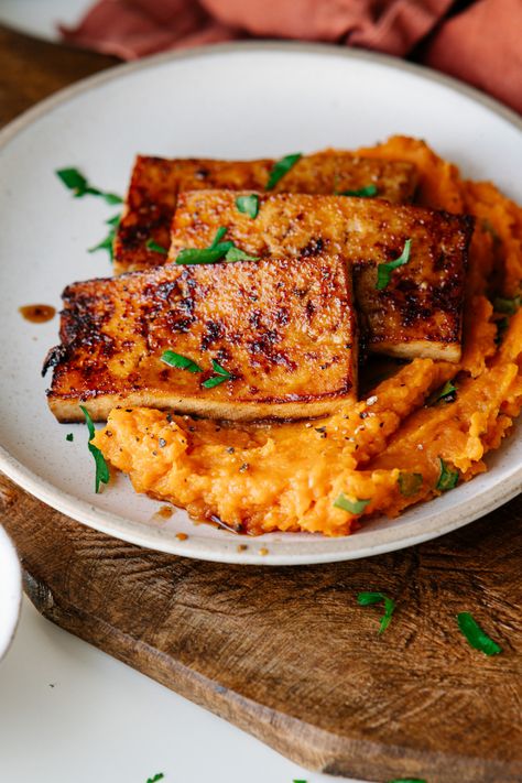 A smoky, savory tofu steak marinated before pan frying and laid on top of a bed of garlicky, herby mashed sweet potatoes. With extra umami marinade drizzled over top. The perfect 30-minute vegan dinner for weeknights! And an impressive main dish for a holiday table. Tofu Thanksgiving Main Dish, Mashed Sweet Potatoes Vegan, Tofu Roast Dinner, Sweet Potato And Tofu, Thanksgiving Tofu Marinade, Vegan Dinner With Sweet Potatoes, 30 Minute Vegan Dinner, Tofu And Potatoes, Tofu And Mashed Potatoes