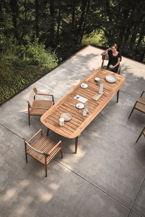 This Teak Outdoor Living Collection Pairs Sustainability and Scandinavian-Inspired Style - Photo 8 of 11 - Inspired by teak decking, and echoing the craftsmanship and design of the Tea Clippers that opened trade routes around the world, Pedersen clearly references his inspiration, using generous deck-like slats, ﬁnely tapered legs that hint at a ship’s mast—even giving the table a hull-like edge. The Clipper collection is simultaneously a nod to a nautical past, as well as a new take on al fresc Modern Outdoor Dining Sets, Modern Outdoor Dining Table, Outdoor Dining Table Setting, Modern Outdoor Dining, Teak Patio Furniture, Natural Teak Wood, Teak Outdoor Furniture, Solid Wood Dining Chairs, Patio Dining Table