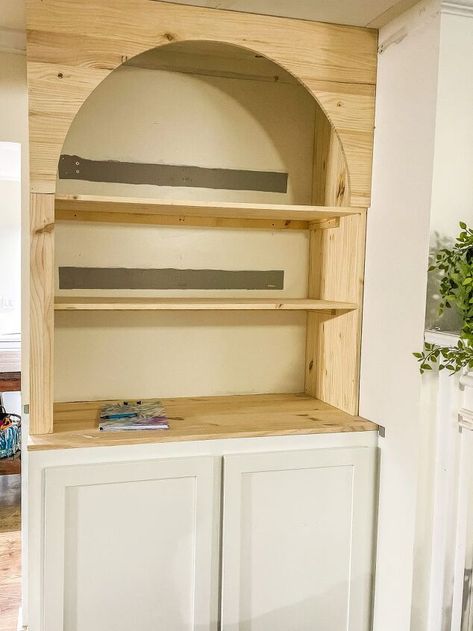 How To Build Arched Bookcases The Easy WayAdd arched bookcases Arch Bookshelf Built Ins Fireplace, Diy Cabinet Bookshelf, Build In Arch Shelf, Book Shelf With Cabinet Base, Build Arched Cabinet, Ikea Hack Arched Bookcase, Build Bookcase, Built Ins Around Arched Doorway, Bookshelf With Arch