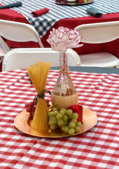 These were the centerpieces we used for an Italian Theme Event. We used real grapes, a chianti bottle, dry pasta and a candle on a charger. And the flower in the chianti bottle was made out of a coffee filter. HSO Italian Table Decorations, Italian Party Decorations, Italian Dinner Party Decorations, Italian Centerpieces, Italy Party, Italian Themed Parties, Dinner Centerpieces, Italian Bistro, Italian Dinner Party