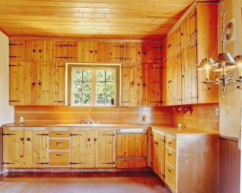 An old kitchen interior with wooden floors, knotty pine kitchen cabinets and ceiling Pine Cabinet Doors, Update Pine Kitchen Cabinets, Knotty Pine Kitchen Ideas, Tongue And Groove Kitchen Cabinets, Natural Pine Kitchen Cabinets, Knotty Pine Cabinets Makeover, Pine Walls Kitchen, Wood Ceilings Kitchen, Knotty Pine Cabinets Kitchen