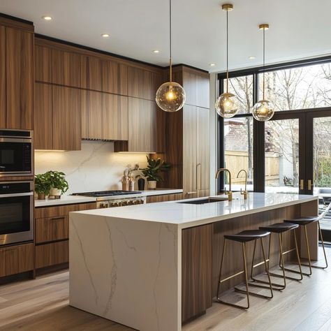 A contemporary kitchen with a sleek, minimalist layout. Warm wooden cabinetry contrasts with matte finishes, featuring gold accents on handles and fixtures. A large kitchen island with a white marble countertop is the centerpiece, surrounded by modern stainless steel appliances. Recessed lighting creates a cozy ambiance, while natural light pours in from large windows, enhancing the earthy tones of beige, soft brown, and cream. Green indoor plants add a fresh touch, blending modern elegance with Contrast Kitchen Island Countertop, Wooden Kitchen With White Countertop, Luxury Cream Kitchen, Cream Gold Kitchen, Bright Open Kitchen, Modern Wood Cabinets Kitchen, Brown Gold Kitchen, Kitchen Natural Wood Cabinets, Cream And Brown Kitchen