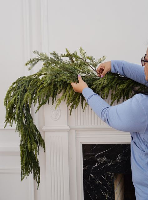 how to hang garland on mantle, how to hang garland on mantel, hang christmas garland, garland on fireplace mantel How To Hang Wreaths On Windows, Mantle Greenery, Garland On Mantle, How To Hang Garland On Mantel, Christmas Fireplace Garland, Christmas Mantel Garland, Battery Operated Christmas Lights, Christmas Fireplace Mantels, Christmas Urns