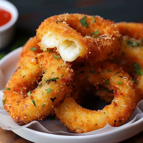 Embark on a culinary adventure with 'Crispy Delight: Mozzarella Stick Onion Rings,' where the beloved appetizer meets innovative cooking. This mouthwatering creation combines the gooey, stretchy joy of mozzarella sticks with the sweet, savory crunch of onion rings, resulting in a fusion snack that's sure to captivate and satisfy. Perfect for parties, game day gatherings, or as a novel treat for family movie nights, these mozzarella stick onion rings offer a fun and flavorful twist on classic ... Mozzarella Stick Onion Rings, Recipes That Use Mozzarella Cheese, Baked Mozzarella Onion Rings, Quick Savory Snacks Simple, Mozzarella Onion Rings, Food Cravings Vegetarian, Mozzarella Donut, Onion Rings Aesthetic, Mozzarella Onion Rings Recipe