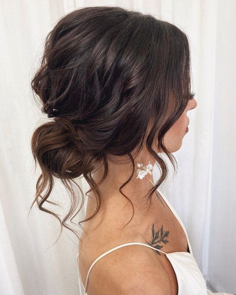 Charming Tousled Bun for Brides Flowy Wedding Hairstyles Loose Updo, Bridesmaid Low Messy Bun, Low Messy Bun Bridal Hair, Loose Wavy Updo, Wedding Hair Messy Low Bun, Bridal Bun Brown Hair, Brown Bridesmaid Hair, Low Bun Bridesmaid Hair Front View, Loose Side Bun Wedding Hair