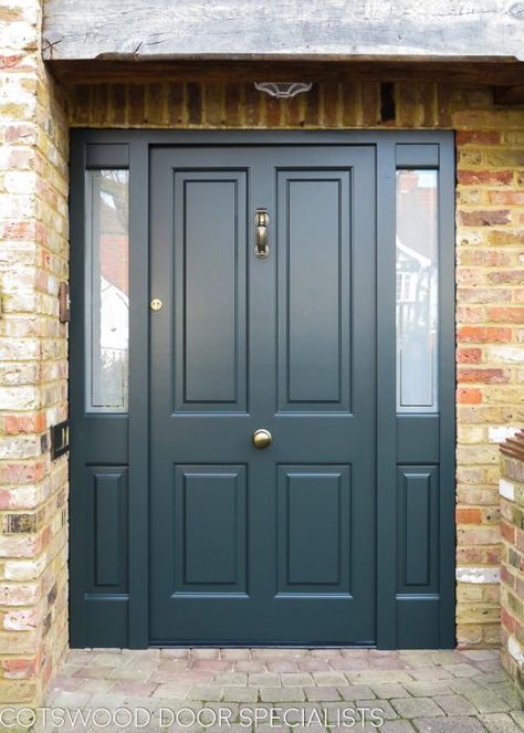 n impressive raised panelled Victorian door, hand-finished in an imposing dark green. The doctor knocker and classic round door knob in antique brass provide stylish accents to this commanding design. Etched glass sidelights retain the homeowner’s privacy, while allowing a flow of natural light. The door frame includes a pair of panels which mirror the classic design of the raised panelled Victorian door. Dark Front Door Ideas, Front Door Side Panel, Four Panel Front Door, Front Door With Sidelight, Dark Green Front Door, Modern Doors Interior, Dark Green Door, Bungalow Windows, Beautiful Bungalows