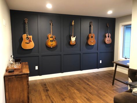 A beatiful way to display guitars. Add a board and batten featured wall! Black Wall Music Room, Cool Home Music Studio, Living Room Guitar Display, Moody Guitar Room, Guitars On The Wall Decor, Wall Mounted Guitars, Music Room In Basement, Guitar Accent Wall, Office With Guitar On Wall