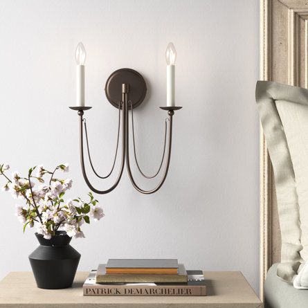 With its sleek lines and sweeping metal accents, this 2-light sconce adds a cozy glow to your space and a French country-inspired accent to your wall. It’s made from steel, with a raised circular backplate and two upward-curving arms that support candle-style fixtures. This wall sconce is compatible with a dimmer switch, to allow you to choose just the right lighting level for your hallway, living room, or bedroom. Two 60W bulbs are sold separately. Finish: Gold Leaf | Corsham 2 - Light Dimmable Traditional Dining Room Chandelier, Farmhouse Wall Sconces, Sconces Living Room, Candle Wall, Rectangle Chandelier, Traditional Chandelier, Dining Room Chandelier, Wall Candles, Metal Accents