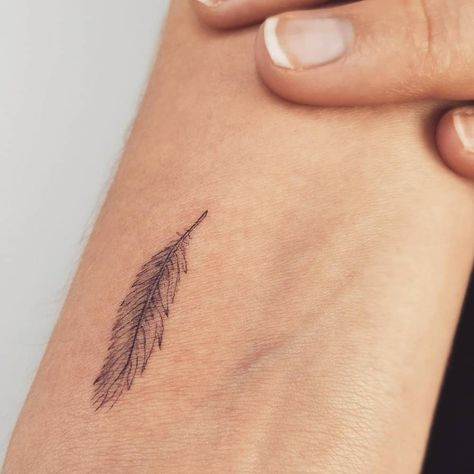 Fine line feather tattoo located on the wrist. Feather Finger Tattoo For Women, Micro Feather Tattoo, Feather Finger Tattoo, Feather Fine Line Tattoo, Minimalist Feather Tattoo, Dainty Feather Tattoo, Feather Wrist Tattoos For Women, Pheasant Feather Tattoo, Simple Feather Tattoo