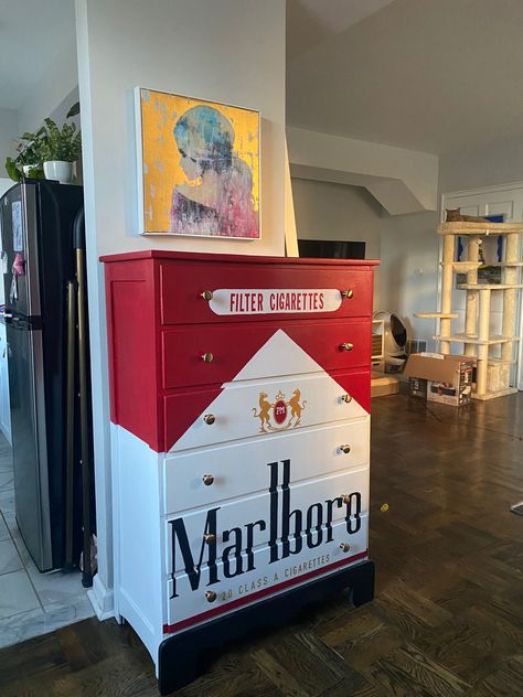 A dresser painted to look like a pack of Marlboro Red Cigarettes Aesthetic Shoe Storage Ideas, Cool Room Wallpaper, Spicy Room Decor, Weird Aesthetic Room, Unique Home Furniture, Random House Decor, Weird House Decor Diy, Graffiti Furniture Ideas, Bar Themed Room