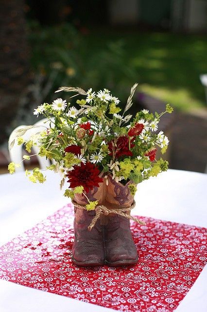 Turn a pair of old cowboy boots into planters. I like how they are tied together with rope. Cowboy Boot Centerpieces, Western Wedding Centerpieces, Boot Centerpiece, Western Centerpieces, Cowgirl Boots Wedding, Wedding Cowboy Boots, Cowgirl Wedding, Quince Decorations, Western Theme Party