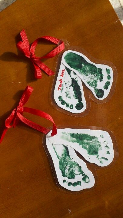 Footprint Christmas tree ornaments (laminated). Easy baby or toddler craft Laminate Christmas Ornaments, Christmas Gifts Childcare, Christmas Laminating Ideas, Christmas Tree Ornaments Homemade Craft Ideas, Christmas Cards For Babies, Infant Daycare Christmas Gifts For Parents, Baby Christmas Ornament Craft, Diy Baby Christmas Ornaments, Toddler Diy Ornaments