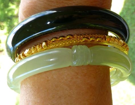 A combination of two basic Chinese jade bangle bracelets, classic green carved and deep deep almost black green with a 24k gold "spacer" bangle.  I love the yin and yang of the light translucent green jade and yang "black" jade, simple jade from the earth, with expensive 24k gold.  #13 in the travel collection. Gold Jade Jewelry, Jade Bangle Outfit, Jade And Gold Jewelry, Jade Bracelet Aesthetic, Green Jade Aesthetic, Jade Bracelet Bangles, Bangle Outfit, Clothing Aesthetics, Bracelets Outfit