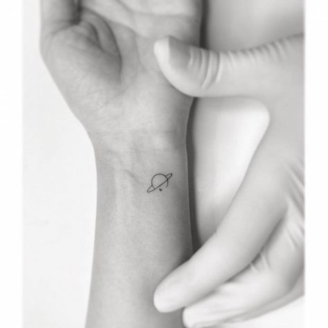 Minimalist Saturn tattoo on the wrist Planet Wrist Tattoo, Mini Jupiter Tattoo, Saturn Tiny Tattoo, Simple Jupiter Tattoo, Small Moon And Saturn Tattoo, Saturn Wrist Tattoo, Small Jupiter Tattoo, Tattoo Of Saturn, Minimal Planet Tattoo