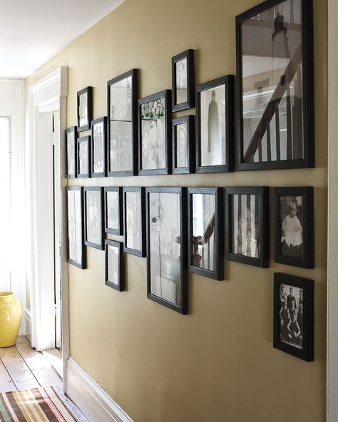 12 Brilliant Ways to Decorate a Blank Wall | A blank wall is like a blank canvas—it's filled with possibilities. What better way to make use of the walls in your home than to celebrate the loved ones who fill it? In this setting, a set of family photographs are unified with identical black frames. The arrangement trick also further elongates the length of the wall.  #homedecor #wallart #marthastewart #diydecor Hallway Pictures, Photo Wall Display, Family Photo Wall, Diy Wand, Hal Decor, Small Hallways, Wall Frames, Wall Gallery, Hanging Pictures