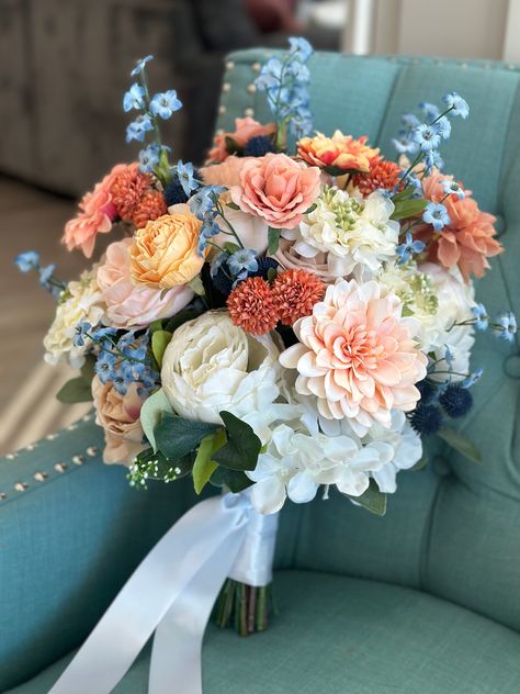 Stunning Bridal bouquet in terra-cotta, off-white, Dusty blue and blush. This bouquet is made with high quality silk flowers consisting of peonies, roses, hydrangeas and eucalyptus leaves. It has all the elegance, beauty and romance you could want and the wow factor you are looking for. Each floral arrangement is handmade with great attention to detail and fine craftsmanship. Bouquets are finished with ribbon color of your choice. You can be sure to love the product you receive and it will last and be beautiful for years to come! *Pictures show 13-14" bride bouquet * This bouquet can be customized to your liking and needs. If you would like a different color palette, different accent or different type of flowers I am very accommodating. I love to work with brides to make you exactly what y Dahlia And Eucalyptus Bouquet, Dreamy Flowers Aesthetic, Wild Flower Bridesmaid Bouquet, Dusty Blue Flower Arrangements, Spring Wedding Bouquets Wildflowers, Bridal Bouquet Types, Bouquet For Blue Dress, Homecoming Bouquet Ideas Blue, Timeless Bridal Bouquet