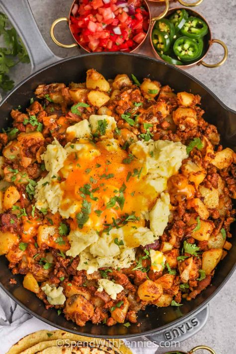 Start the day off right with this chorizo hash recipe. Spicy or sweet chorizo sausage is fried with bacon and then cooked with smooth and silky Yukon Gold Potatoes. Topped with eggs and cheese and then baked in the oven, this chorizo hash is so cheesy and filling. Make it a complete breakfast with a cup of coffee or tea!  #chorizohash #chorizobreakfast #beakfastchorizohash #spendwithpennies Papas And Chorizo, Mexican Breakfast For A Crowd, Chirozo Breakfast Recipes, Best Mexican Breakfast Recipes, Chorizo And Beans, Chorizo Dinner Ideas, Spanish Sausage Recipes, Breakfast Nachos Scrambled Eggs, Mexican Brunch Recipes