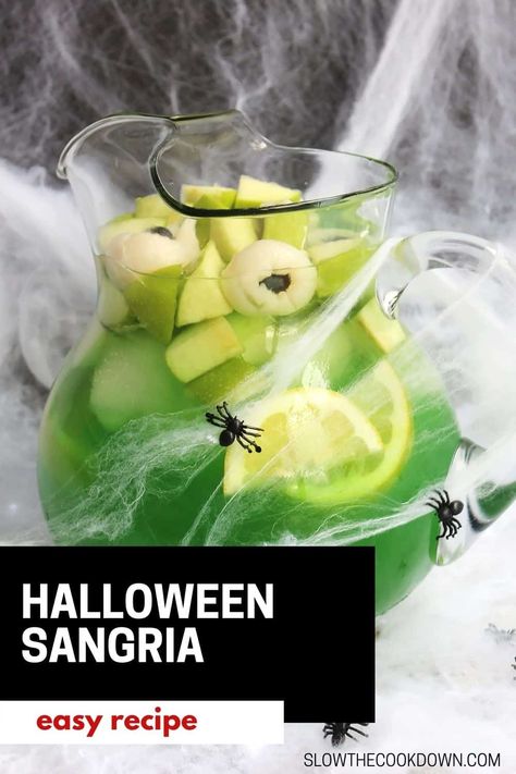 Get your spooky on with this easy and fun Green Halloween Sangria! This fun colored punch is perfect for a crowd and is flavored with limoncello and apple, then topped off with some lychee eyeballs! Make it ahead of time for a Halloween cocktail that everyone will love! Sangria Recipes With Rum, Halloween Sangria, Easy Halloween Cocktails, Halloween Themed Drinks, Green Cocktails, White Wine Sangria Recipe, Halloween Party Drinks, White Wine Sangria, Halloween Drinks Alcohol