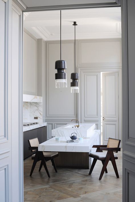 In the kitchen, all technical elements are hidden behind calacatta marble partitions. Bronze ‘Fingi’ suspension lighting by Eric Schmitt (Eric Schmitt). Office armchairs by Pierre Jeanneret (Galerie 54).  http://www.yatzer.com/joseph-dirand-saint-germain-paris // Photo © Adrien Dirand / AD France n° 119, September/October 2013. Modern French Interiors, Glamorous Kitchen, Joseph Dirand, Minimalist Dekor, Parisian Apartment, Paris Apartments, Kitchen Marble, Design Del Prodotto, French Interior