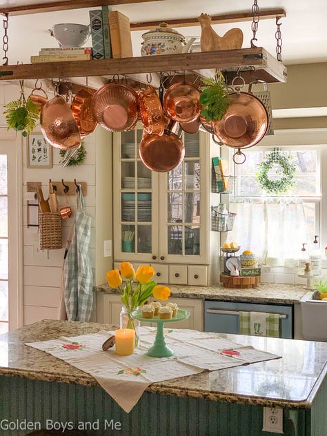 Farmhouse style kitchen with diy pot rack andspring decor - www.goldenboysandme.com Pot And Pan Ceiling Rack, Ladder Pot Rack Rustic, Pot And Pan Hanger Ceilings, Ceiling Pan Rack, Kitchen Pot Hanger Ideas, Ceiling Rack Kitchen, Farmhouse Pot Rack, Pot Rack Decorating Ideas, Hanging Pot Rack Decorating Ideas